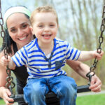 child on a swing smiling