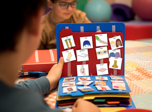 standard PECS communication book being used in a school setting