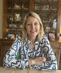 Smiling woman sitting in front of a cabinet 